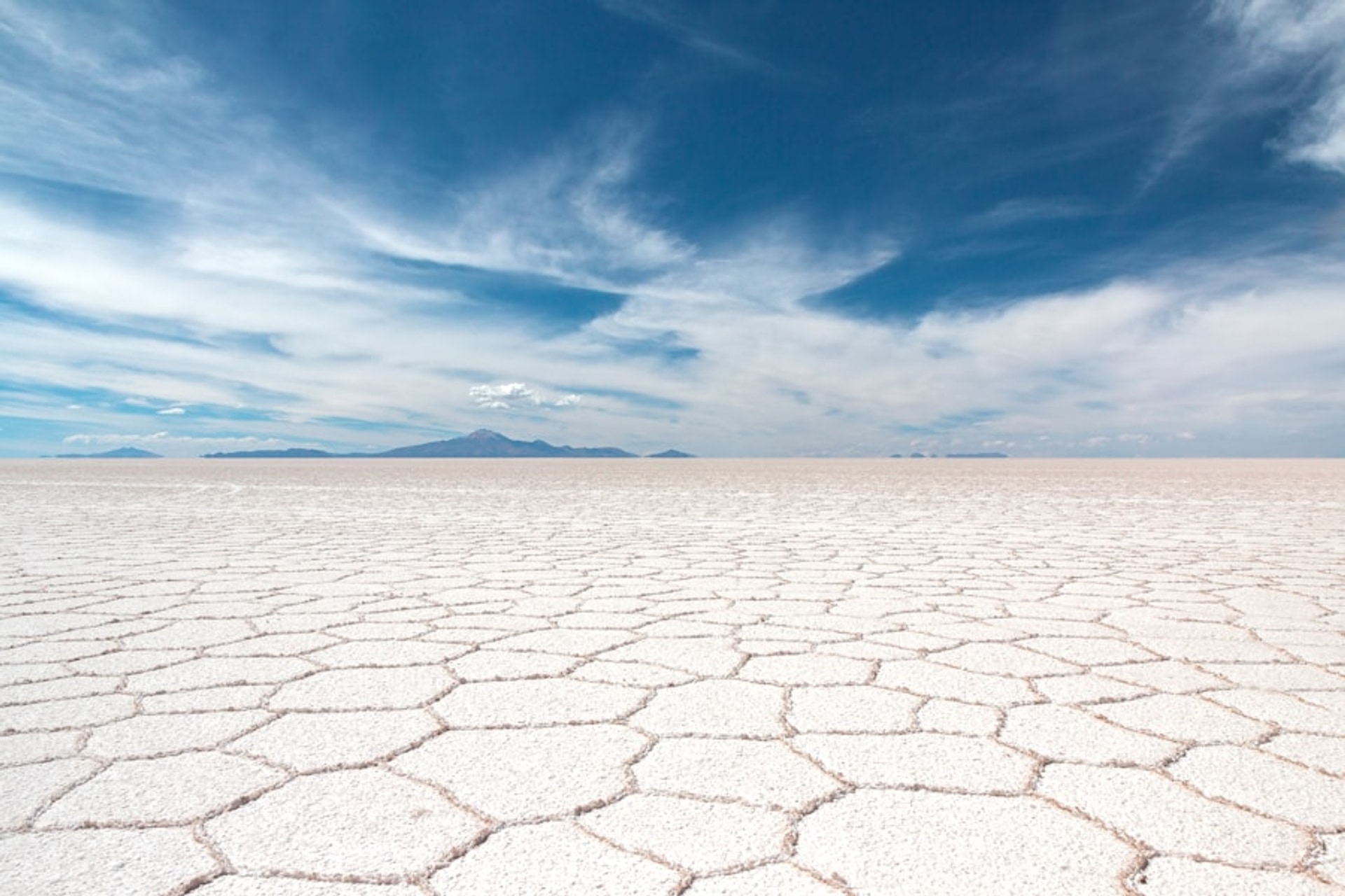 Salar de Uyuni espelhando o céu azul na Bolívia